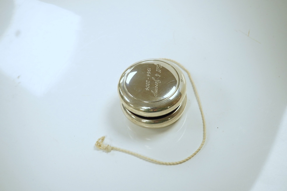 A modern silver mounted yo-yo, Practical Silverware, London, 2003, 56mm, with engraved inscription. Condition - fair to good